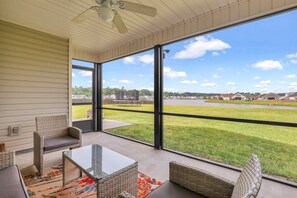 Screened-in family patio area, overlooking the backyard and lake.