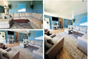 Large living room with high ceilings, a large sectional and a smart TV.