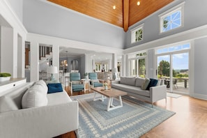 Bright open living room with 2 sofas -  a bar table behind one sofa
2 accent chairs & 2 swivels in corner by lake. Perfect to watch tv or turn and enjoy the lake view.