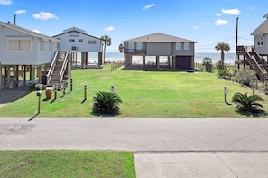 View from upper deck. Within a few minutes you can have your toes in the sand! The road shown is a neighborhood road, not the main highway. This home is beachside! No crossing a busy highway.