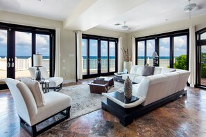 Living area with plush sofa seating and sweeping ocean views. 
