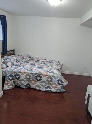 master bedroom with queen bed and single sofa with in-suite washroom
