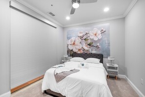Cozy and serene bedroom with a plush queen bed and soft lighting, perfect for restful nights.