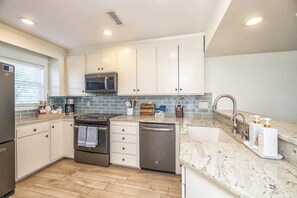 Updated kitchen with sleek granite countertops and coffee station.