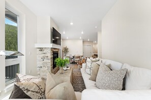 Living area offering cozy furniture, gas fireplace, mounted flat screen TV, and large windows with incredible views.