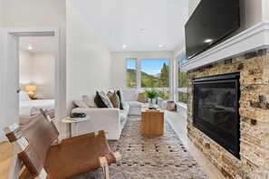 Living area offering cozy furniture, gas fireplace, mounted flat screen TV, and large windows with incredible views.