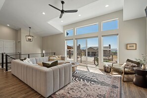The living room, freshly appointed with comfy furniture, a smart TV and fireplace, offers easy access to the outdoor deck and spectacular views.