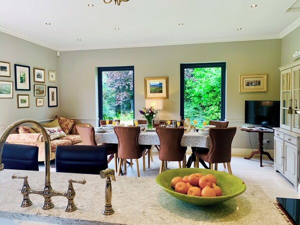 Open plan kitchen dinner with a log burning stove & far reaching views.