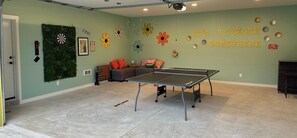 There is a game room in the garage with plenty of amenities for all to enjoy. You can play ping pong, darts, corn hole, or more.