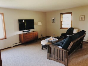 Living room with futon and smart tv.
