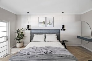 The upper floor bedroom is spacious and features an elegant and clean design with a large wardrobe.