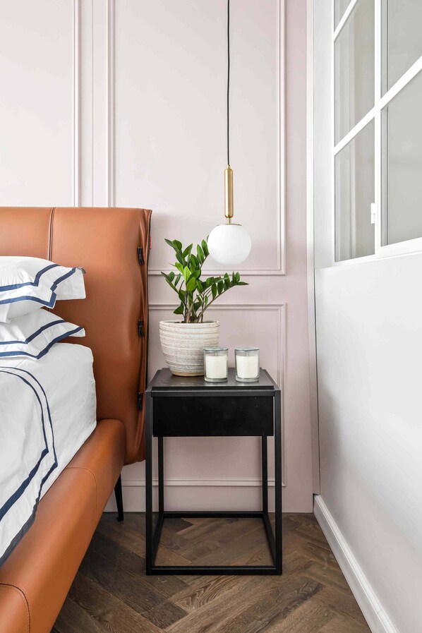 Stylish bedroom featuring a unique accent wall, contemporary lighting, and a high quality leather bed frame.