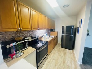 Step into a well-appointed kitchen designed for convenience. It includes a full-sized refrigerator, range, and plenty of counter space for meal prep. You'll find generous storage in the cabinetry, making it easy to keep things organized.