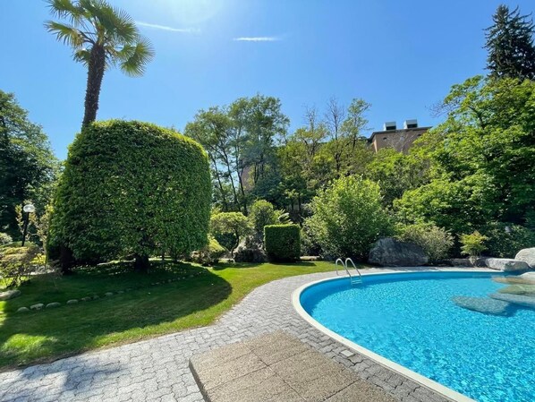 Large outdoor swimming pool with lawn. 
