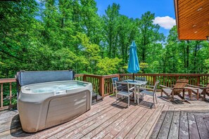 The deck includes a hot tub, outdoor dining table and additional seating.