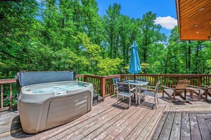 The deck includes a hot tub, outdoor dining table and additional seating.