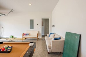 Garage is set up with a mini split for comfort, convertible pool table/air hockey, and seating.