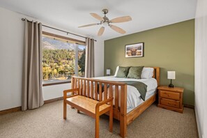 Primary bedroom, located upstairs, with a queen bed, mountain views & full ensuite bathroom