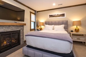 Elegant bedroom with a cozy fireplace, plush bedding, and sophisticated decor for a serene retreat.
