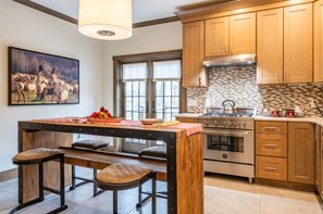 Gourmet kitchen equipped with modern appliances, granite countertops, and a stylish breakfast bar, perfect for culinary creations.