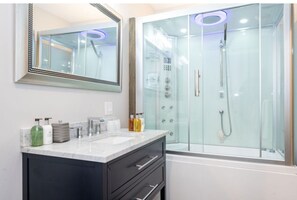 Elegant bathroom featuring a luxurious shower and tub combination with modern fixtures and ambient lighting for a relaxing experience.
