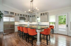 Spacious and modern kitchen with ample natural light, high-end finishes, and an inviting ambiance for culinary delights.