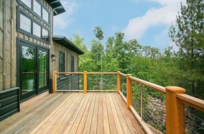 Expansive deck at Laurel Ridge Modern Cabin, offering serene views and a perfect space for outdoor relaxation and entertainment.