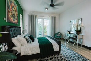 A MASTER bedroom with a queen sized bed and an en-suite with bathtub
