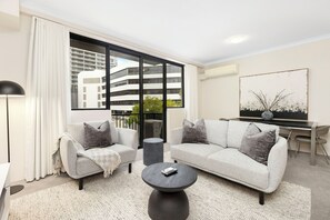 The living room, with its chic decor and sophisticated ambiance, offers a retreat for relaxation, reflecting a high standard of urban living.