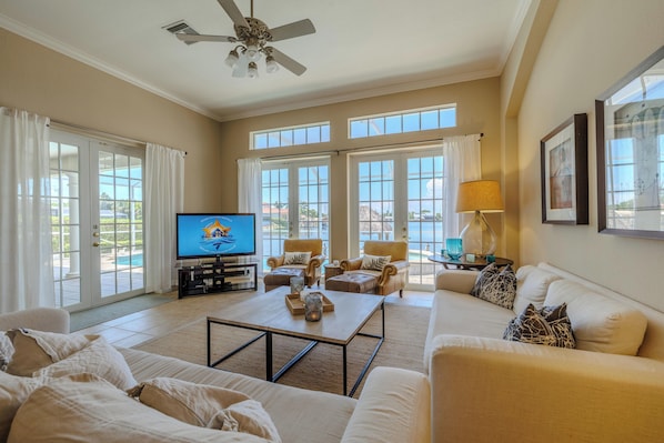 Elegant Comfort - - Inviting living space, where style meets relaxation & sunlight fills the room
- French doors & large windows offer stunning views, creating a seamless indoor & outdoor vibe
- Plush seating & thoughtful decor make it perfect for entertaining