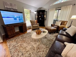 Living room open to dining and kitchen. Leather sofa and chair.