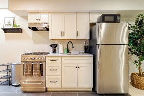 Kitchen with stove, oven, fridge/freezer microwave and cooking essentials