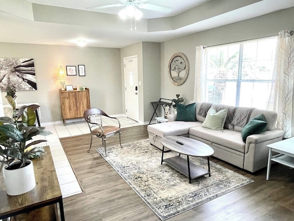 View of the entryway and living area from the hallway. The sofa can turn into a third bed and the wine cabinet contains wine glasses and accoutrements.