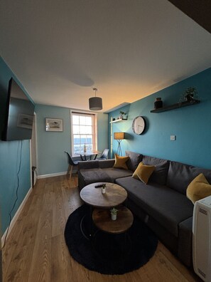 Open plan living room with sea view and 55 inch TV