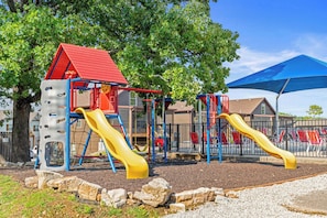 Slides, swings, and climbing features await at the playground by the pool