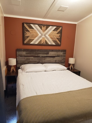 Bedroom with queen bed, bedstands, lighting and charging ports. Closet w/hangers