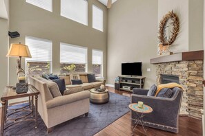 Living Room: Large L-shaped couch, reading chair, gas fireplace, TV