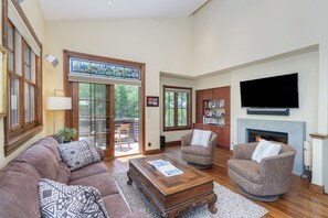 Open living area, with gas fireplace, where a balcony extends the living space outdoors, providing the perfect spot for soaking in the fresh mountain air.