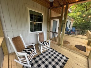 Screened porch on deck overlooks pond and dock.