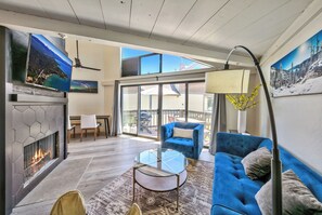 Wood fireplace in the living room with a 50-inch TV above it with plenty of seating