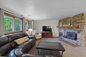 Main living space includes comfortable seating, Smart TV and wood burning stove