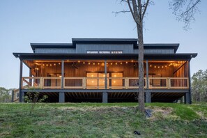This riverfront chalet features a large, covered back porch with string lights, comfy seating, and unbeatable views.