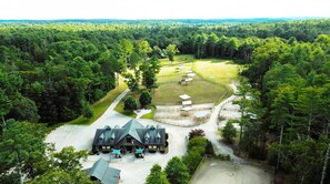 Expansive aerial view of the property, showcasing the lush greenery, multiple structures, and spacious grounds.