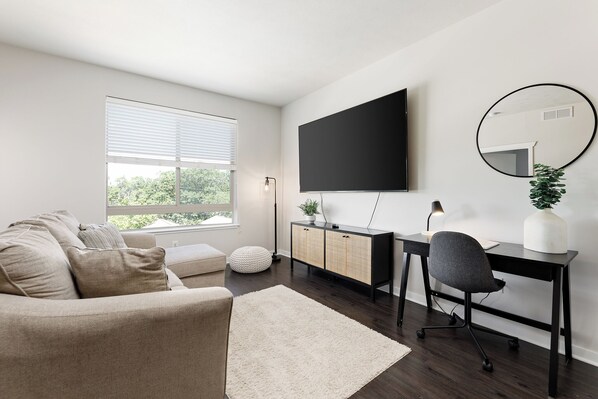 Our inviting living room with 85" Smart TV is complete with our comfortable, new sleeper sofa!