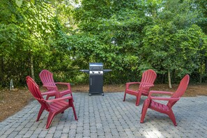 Private patio with seating and a BBQ grill, perfect for outdoor dining and relaxation.