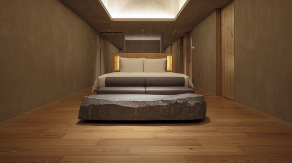 [SOKI Suite] 66 m² / bed width 1,800 mm. Equipped with a sofa and a stone table.