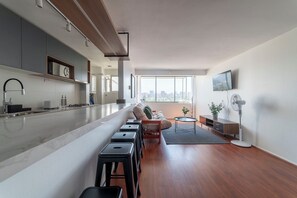 Experience urban living with stunning city views in this modern open-plan living space, perfect for relaxation and entertainment.