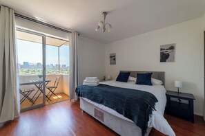 Relax in this cozy bedroom with a stunning city view from your private balcony, perfect for morning coffee or an evening unwind.
