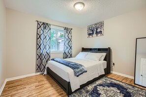 Cozy bedroom 2 with plush beddings and window with curtains