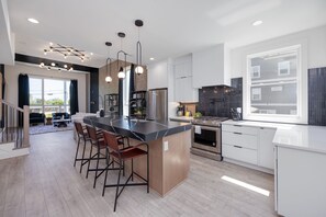 1st Floor: The fully equipped kitchen is stocked with all culinary essentials and boasts brand-new stainless-steel appliances with an oversized kitchen island offering bar seating.